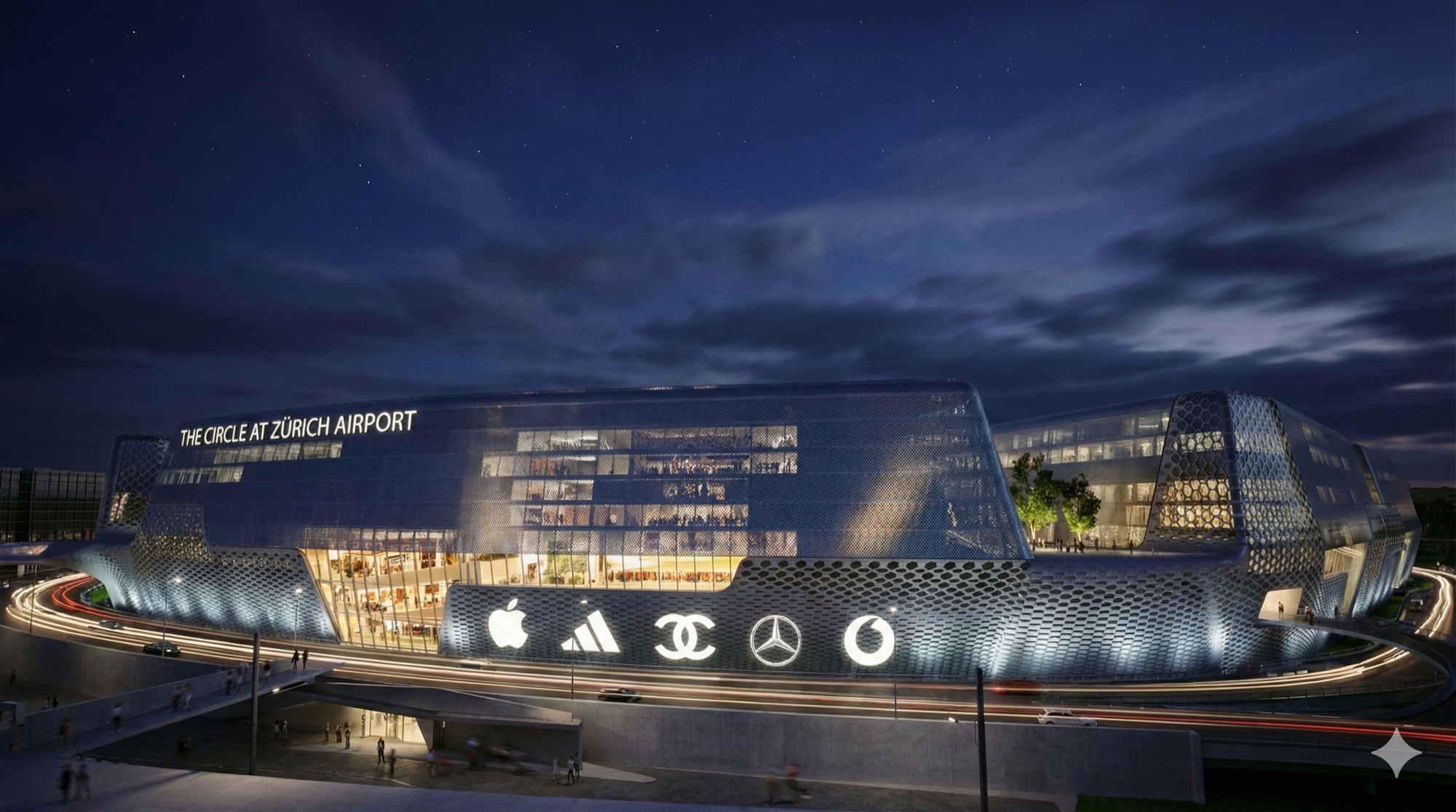Night view of The Circle at Zurich Airport with illuminated brand signage and curving glass facade