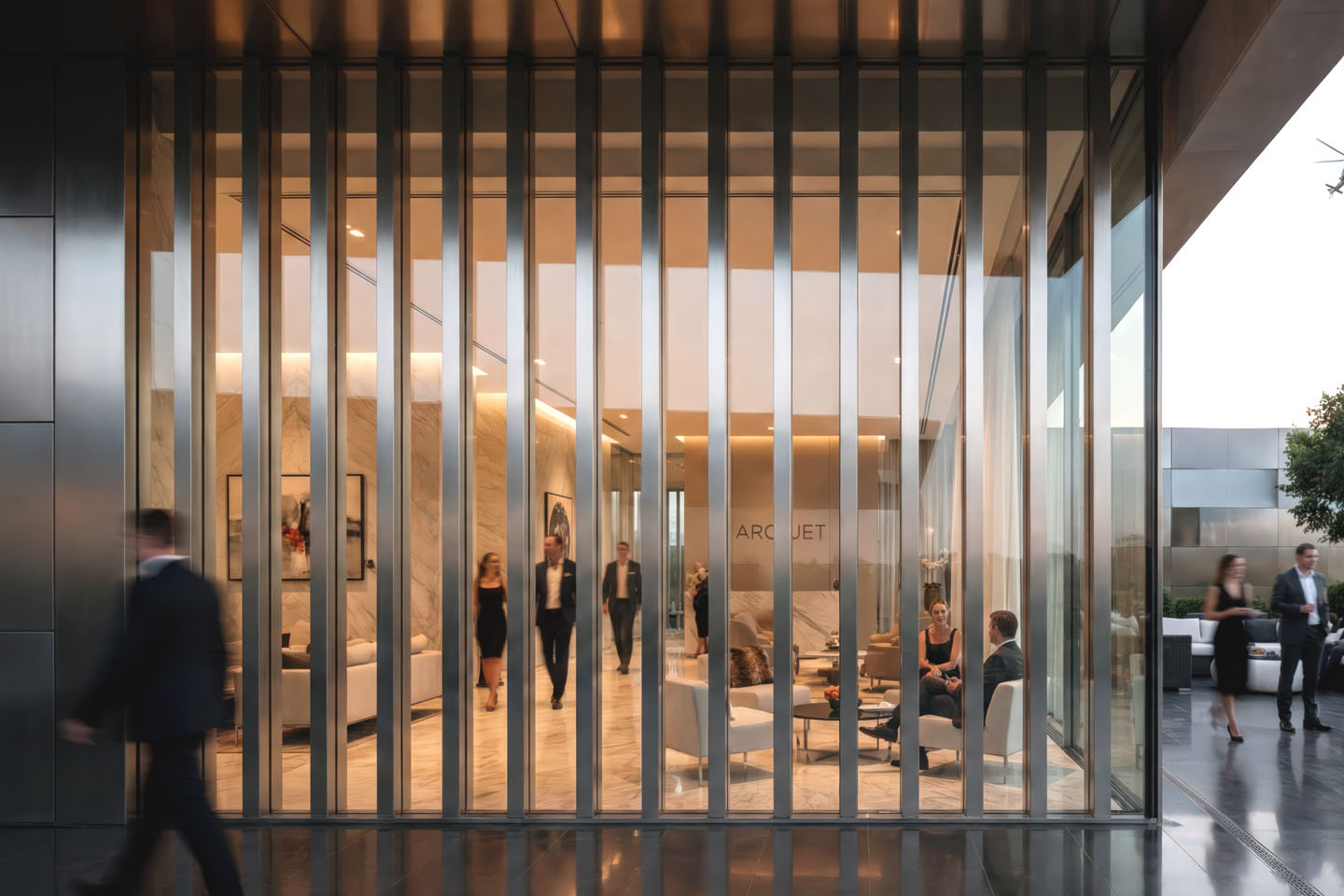 View through vertical metal louvers into a warmly lit VIP lounge with marble walls, contemporary furnishings, and Arcosjet signage