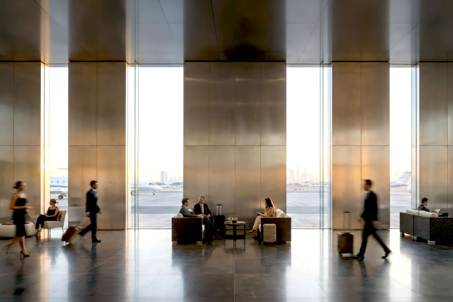 VIP departure lounge with tall brushed brass panels alternating with full-height glazing, private jets and Dubai skyline visible at golden hour