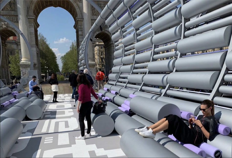 Daytime interior view with visitors walking through the pavilion beneath the Arco della Pace