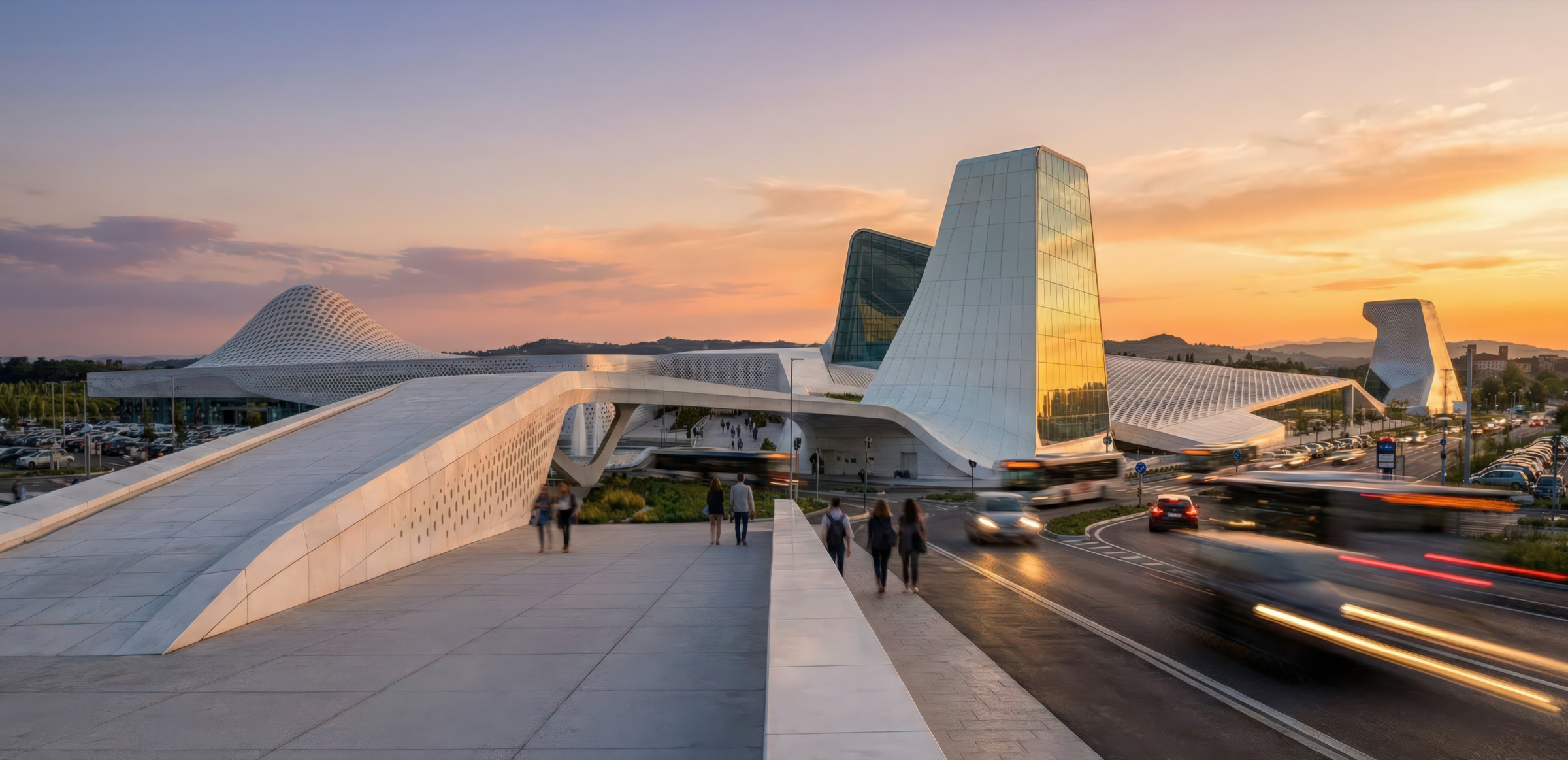 Panoramic sunset view of the Azzano complex showing sculpted white volumes, glass towers, and a pedestrian bridge with motion-blurred traffic