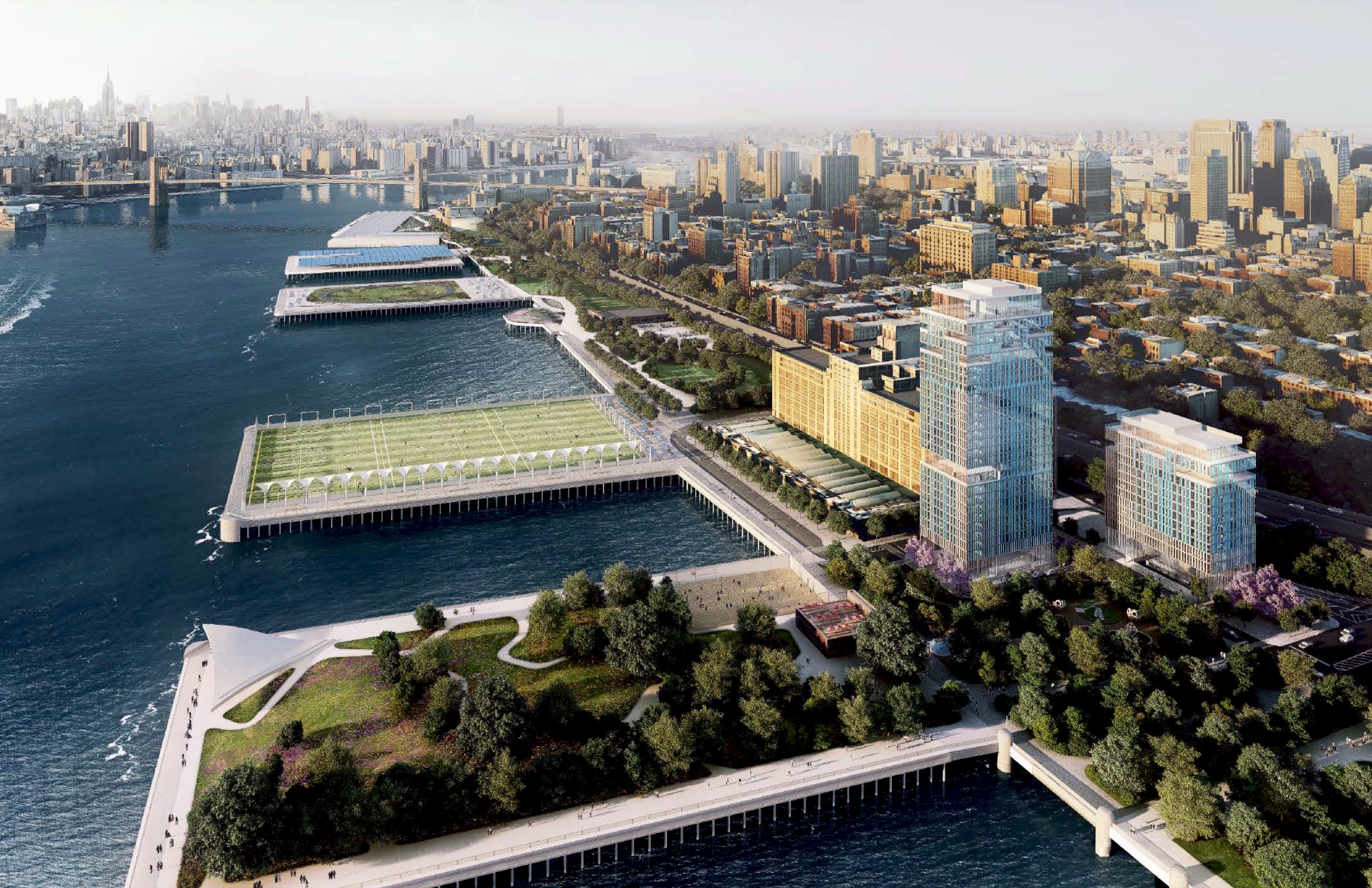 Aerial view of Brooklyn Bridge Park and Pier 6 residential development with piers, sports fields, East River, Brooklyn Bridge, and Lower Manhattan skyline