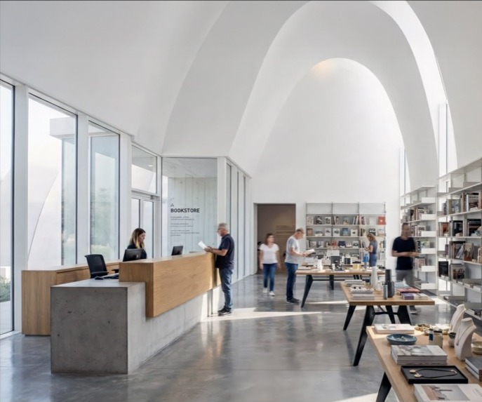 Carob Arts Center bookstore interior with arched vaults, natural light, and display tables
