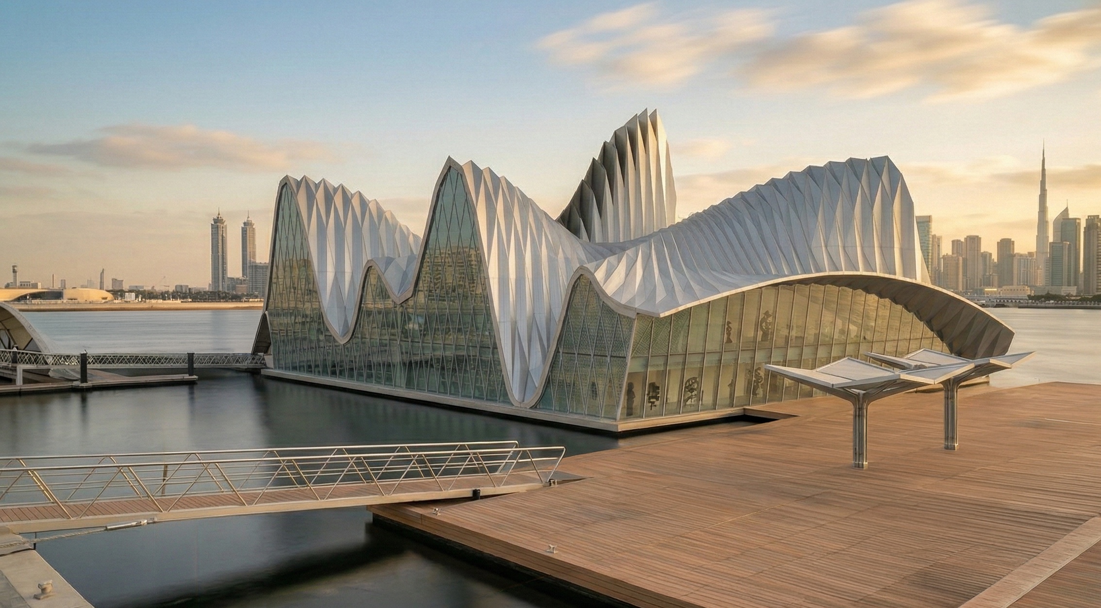 Exterior view from the boardwalk showing the arts center's sculptural wave-like roof canopy with the Burj Khalifa visible on the distant skyline
