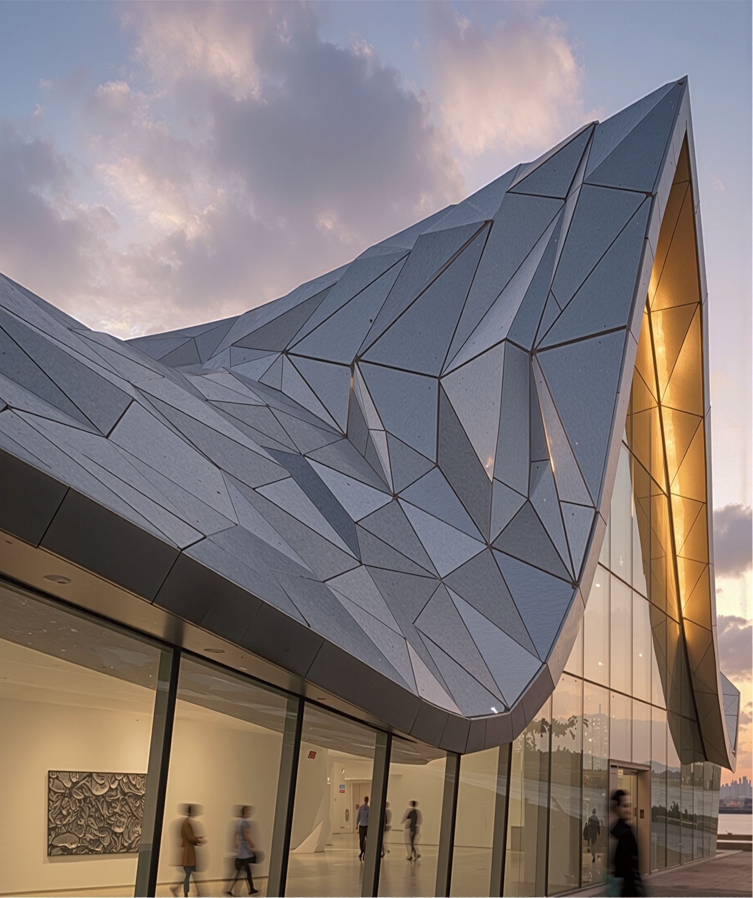 Close-up exterior detail of the faceted tessellated metal cladding panels at the building entrance, with warm light glowing from beneath the sweeping roof canopy
