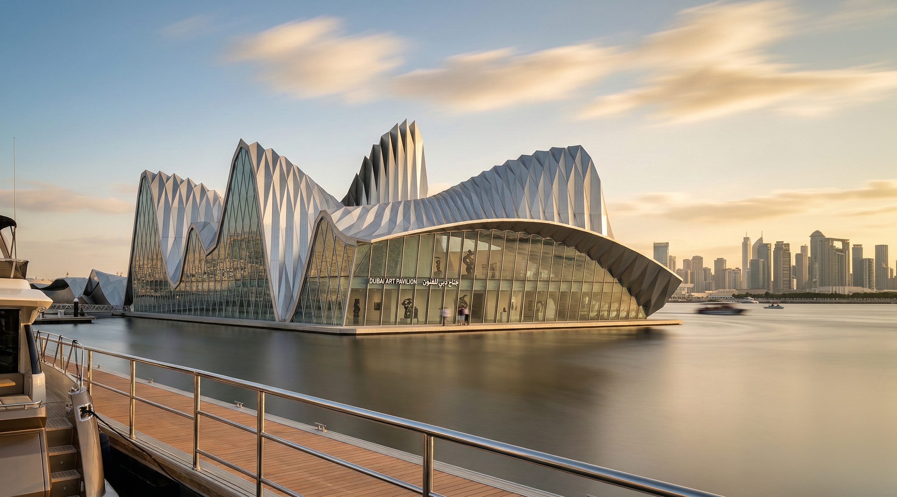 Waterfront view of the Dubai Contemporary Arts Center with its dramatic undulating metallic roof fins rising above a glass pavilion, set against the Dubai skyline at golden hour