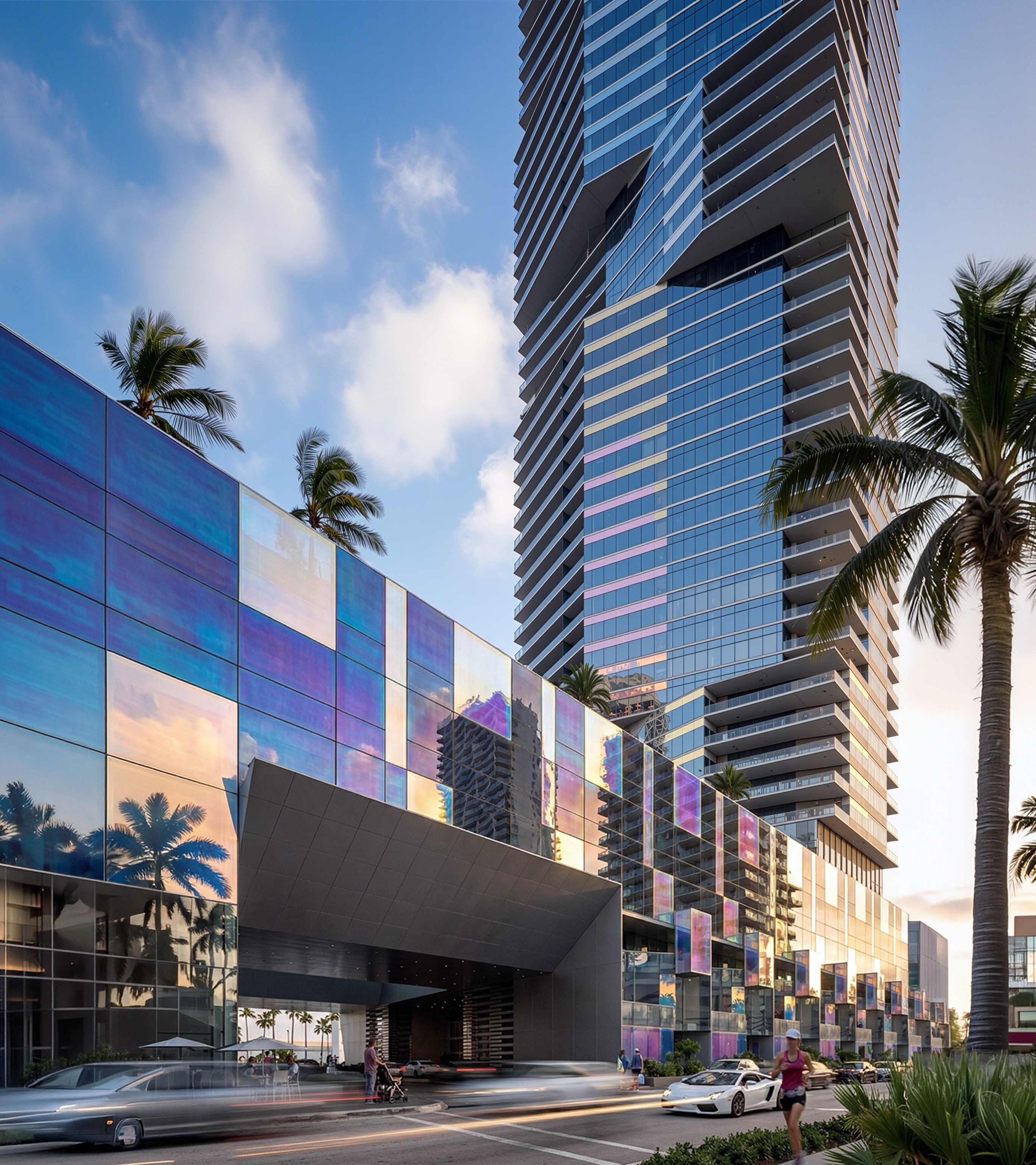 Vertical perspective of the twin towers rising above the iridescent podium base with palm trees and pedestrians at street level