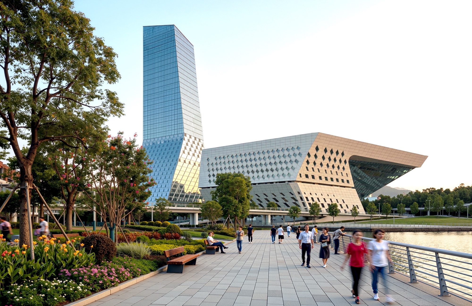 Street-level view from the waterfront promenade showing pedestrians, landscaped gardens, and the tower rising behind the angular performing arts volume