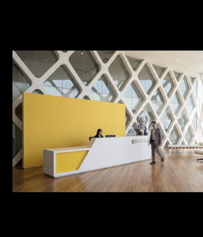 Exness Headquarters reception lobby with yellow branded desk and diamond-pattern glazing