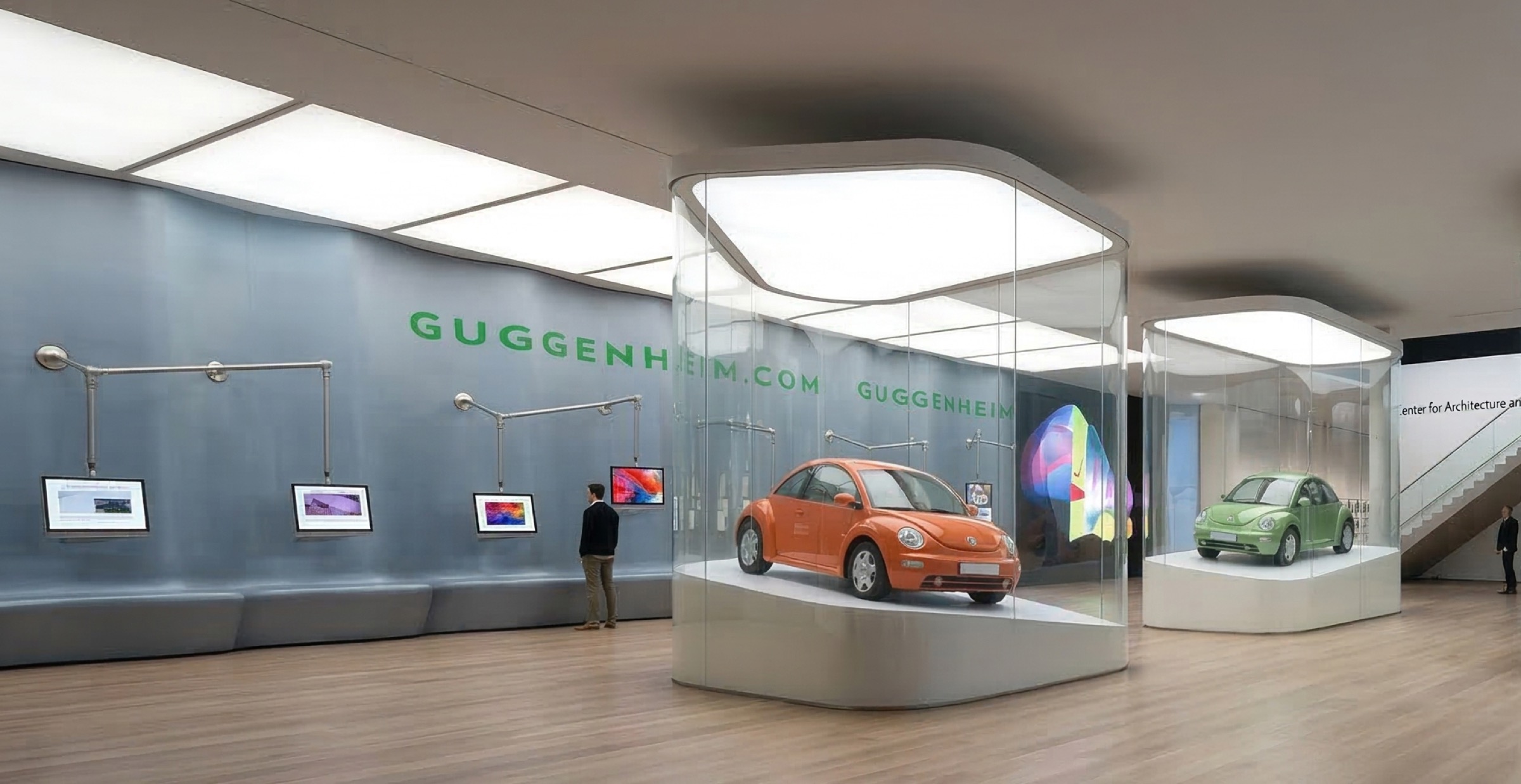 Deep interior view with multiple glass vitrines under luminous ceiling panels, articulated screen wall with GUGGENHEIM.COM branding, and angular staircase beyond