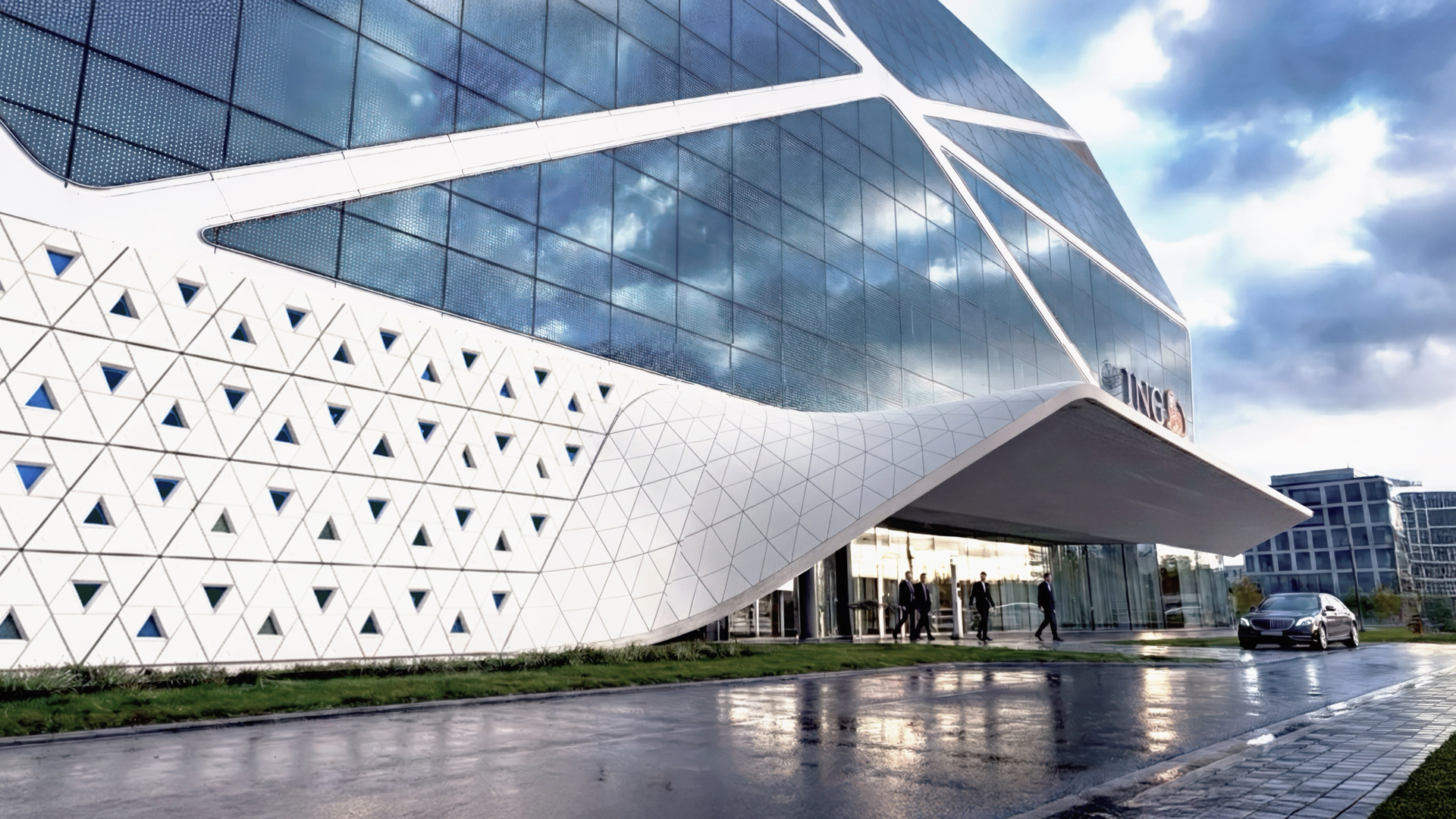 ING Headquarters entrance with GFRC panels and glass facade reflecting dramatic clouds