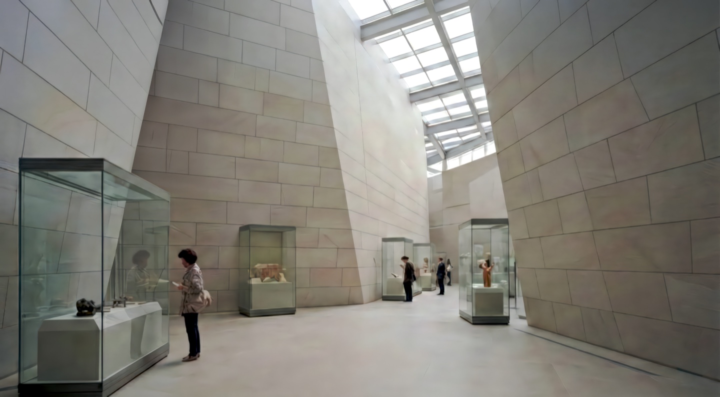 Exhibition gallery lined with monumental sandstone walls and glass display cases housing historical artifacts beneath a linear skylight