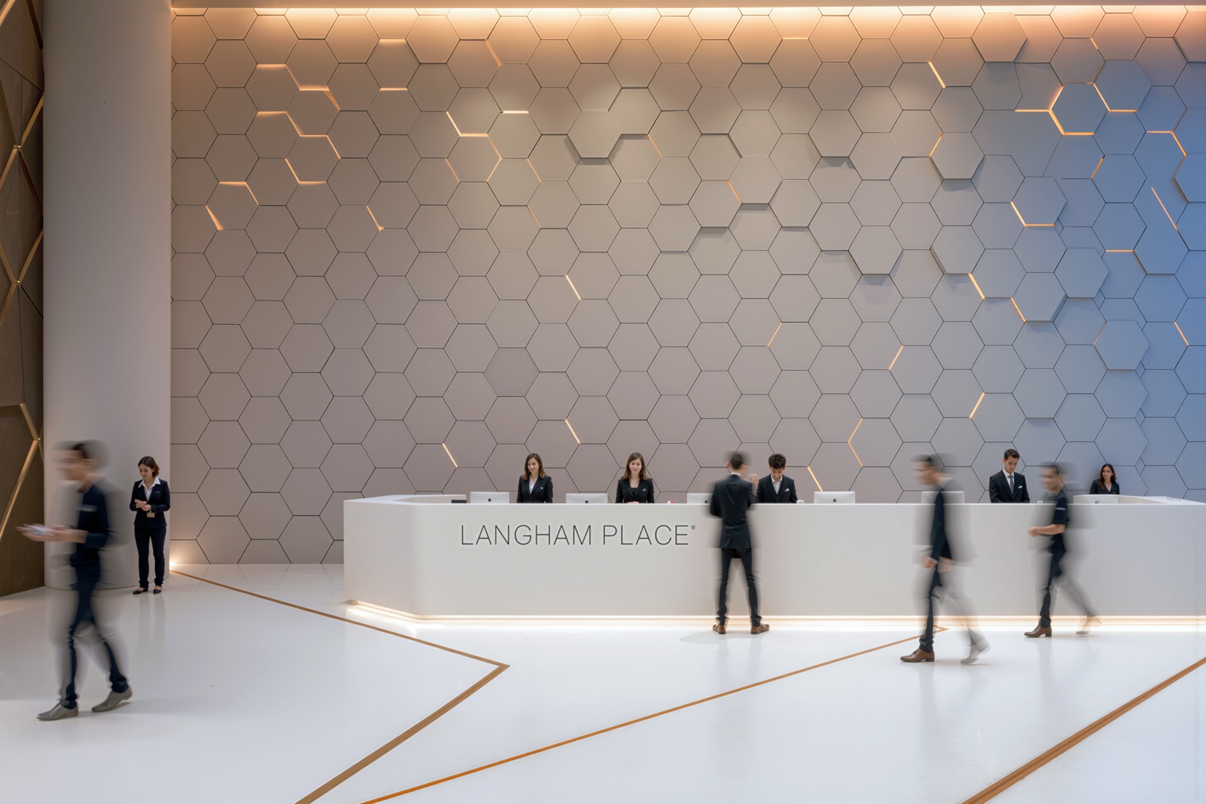 Langham Place reception desk with three-dimensional hexagonal feature wall backlit with warm amber accents, staff attending motion-blurred guests, and gold inlay floor pattern