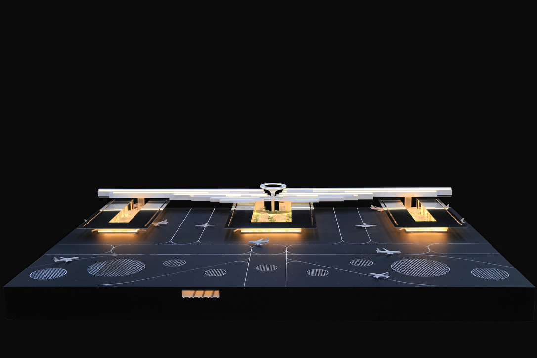 Physical model aerial overview of the terminal complex showing the horizontal canopy structure with central oculus element and gate concourses