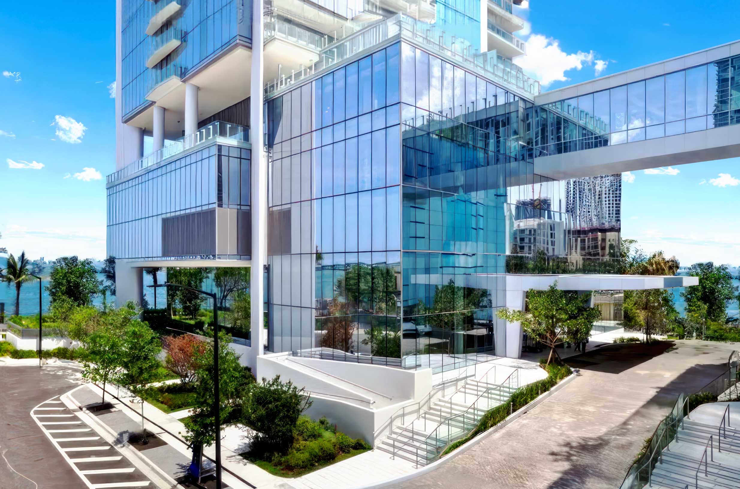 Close aerial view of the Missoni Baia glass podium and entrance lobby with waterfront views and surrounding neighborhood