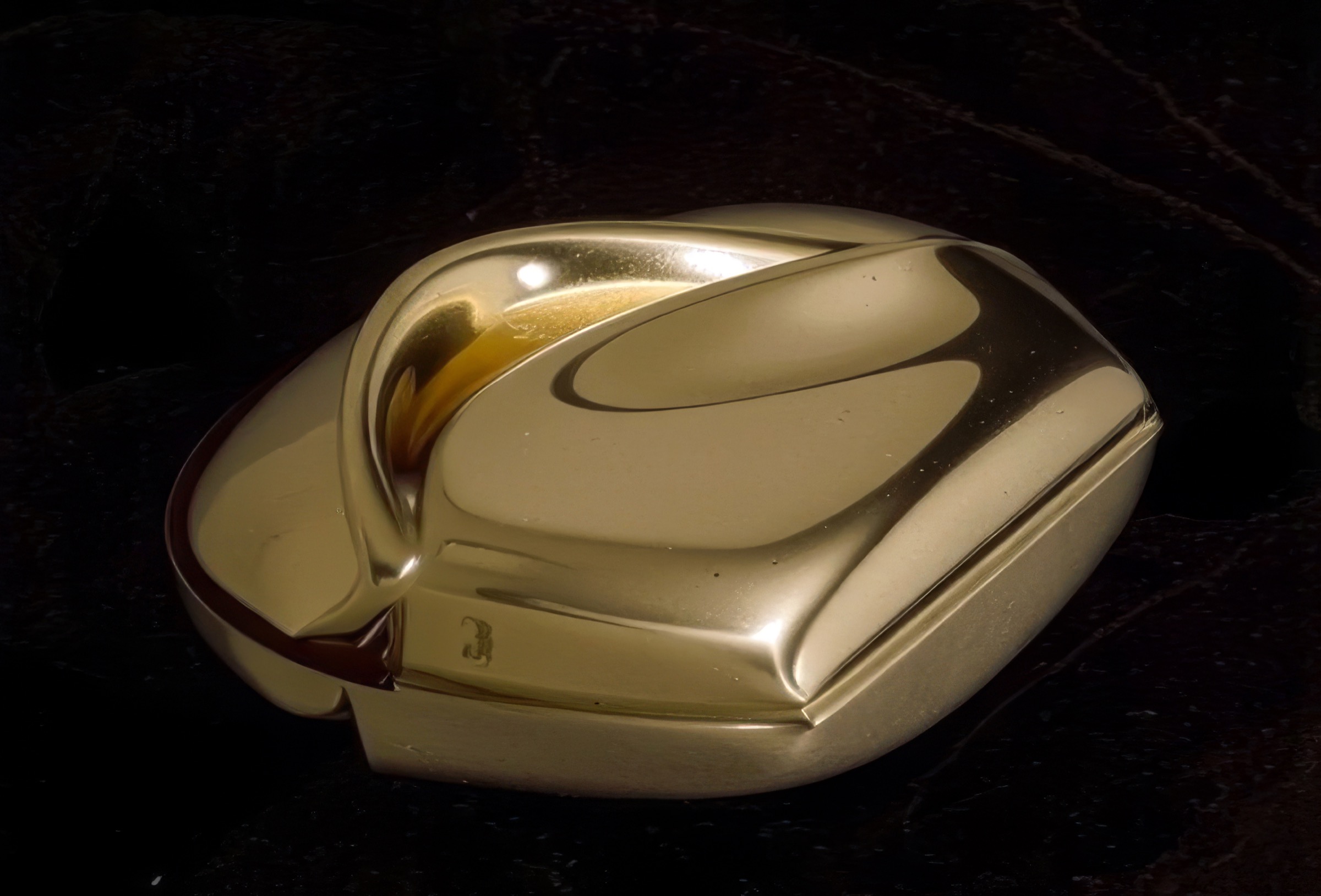 Mnemos 03 closed — the organic gold vermeil form from a second angle on dark marble