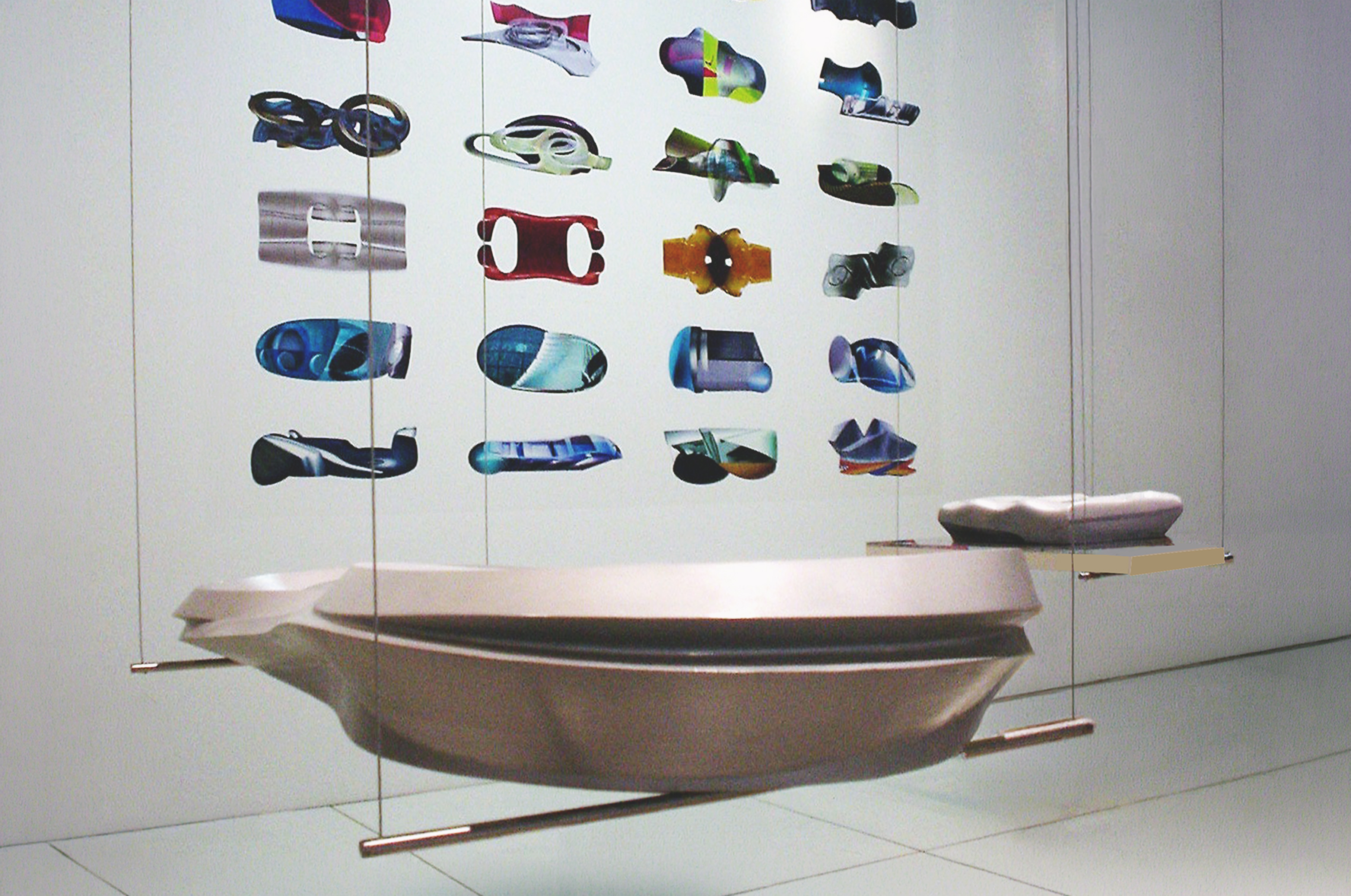 Asymptote's suspended model — a large biomorphic form displayed with a backdrop of colorful project renderings