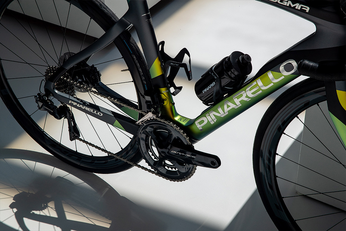 Detail of the Dogma F12 bottom bracket and drivetrain — iridescent green-gold paint shifting across the down tube and chainstays with Shimano Dura-Ace crankset