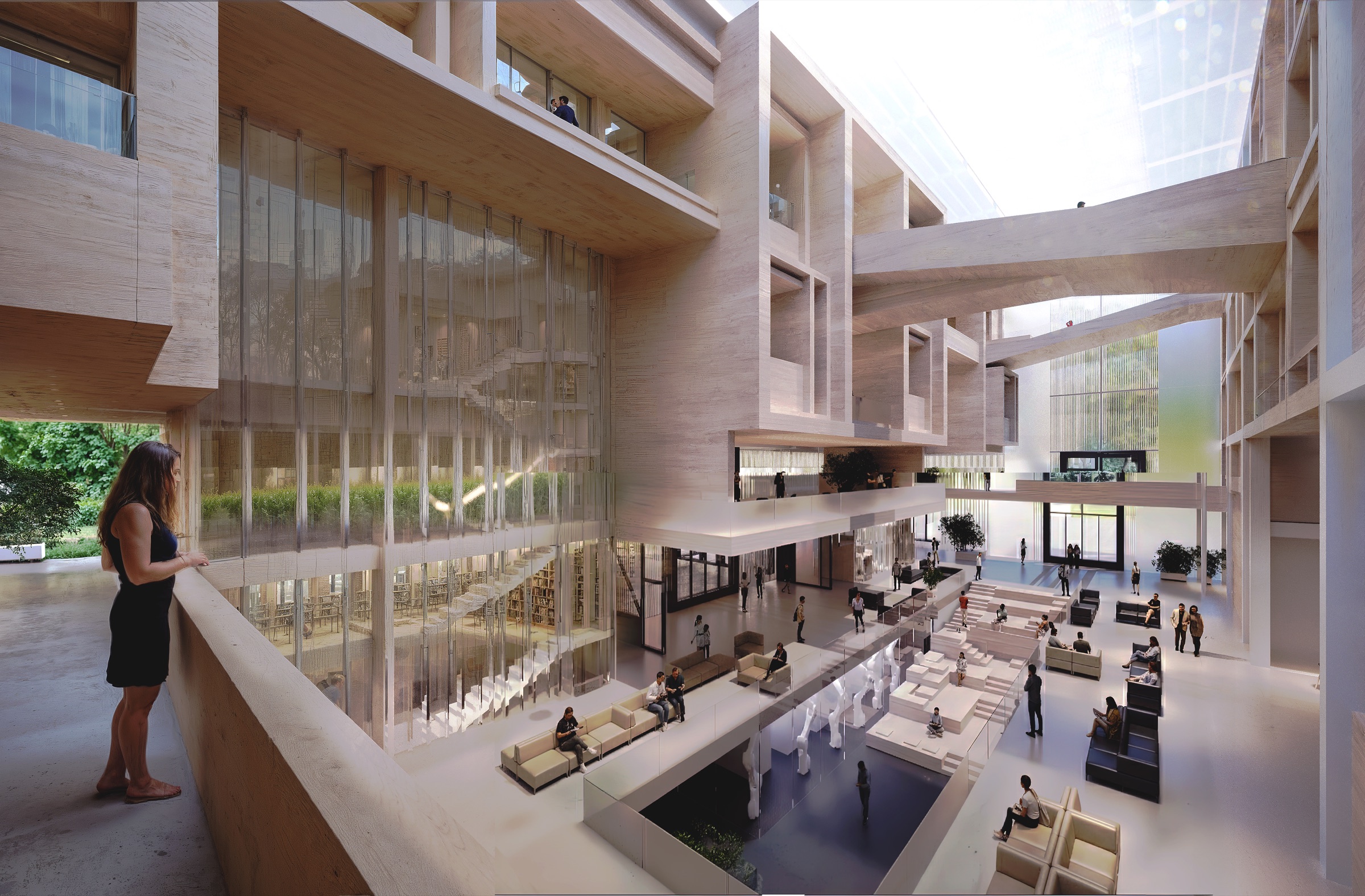 View from the upper mezzanine looking down into the central atrium, showing the full multi-level volume with timber-lined walls, a glazed reading room overlooking the atrium, visitors on the ground floor below, and large-scale glazing framing the campus landscape