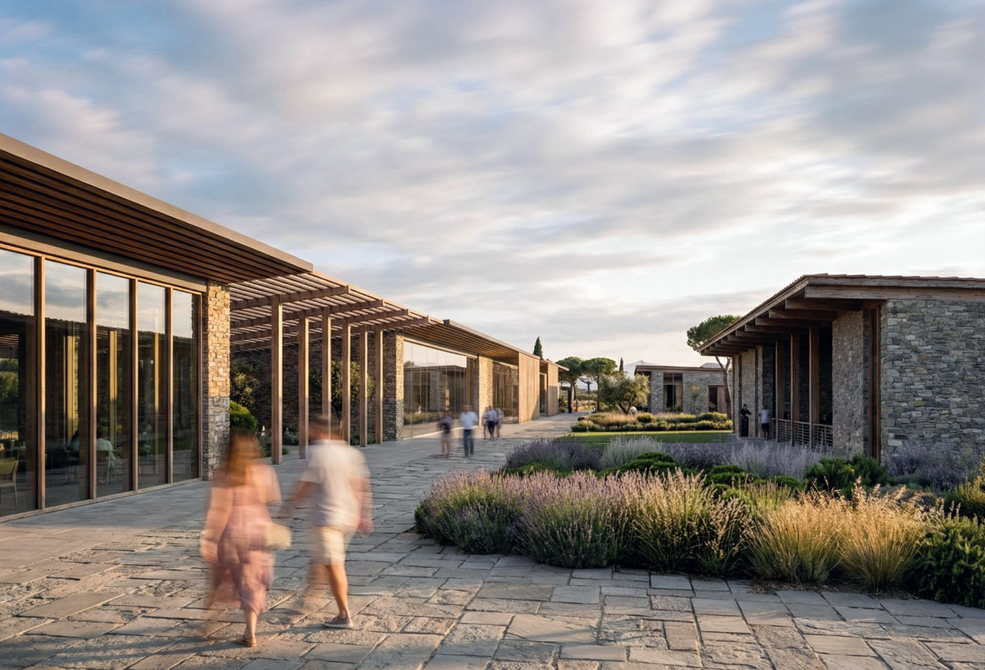 Central pedestrian spine with glass-fronted pavilions, stone walls, and lavender landscaping