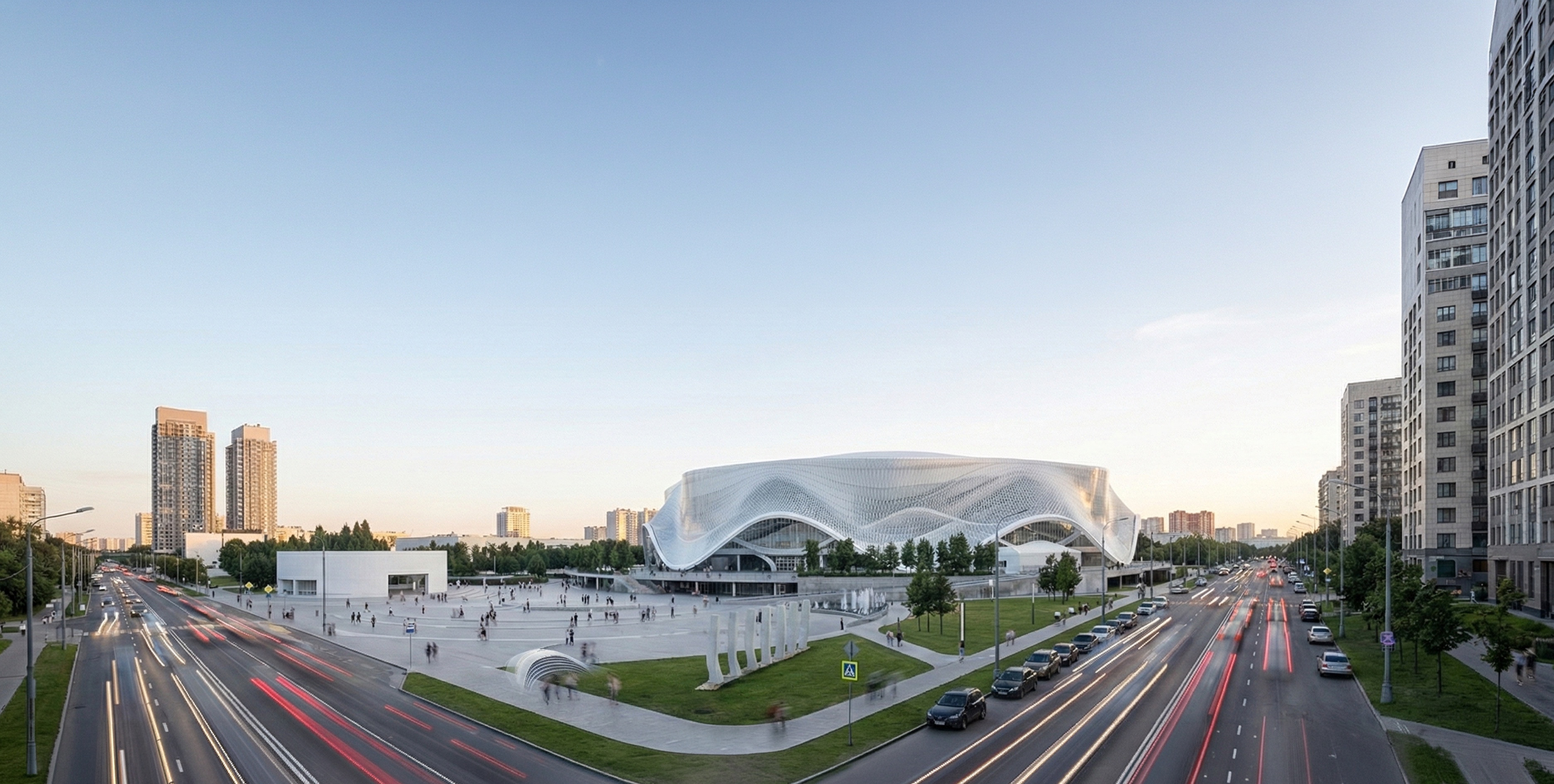 Panoramic cityscape view of SKA Arena with its flowing white facade set among Saint Petersburg boulevards at dusk