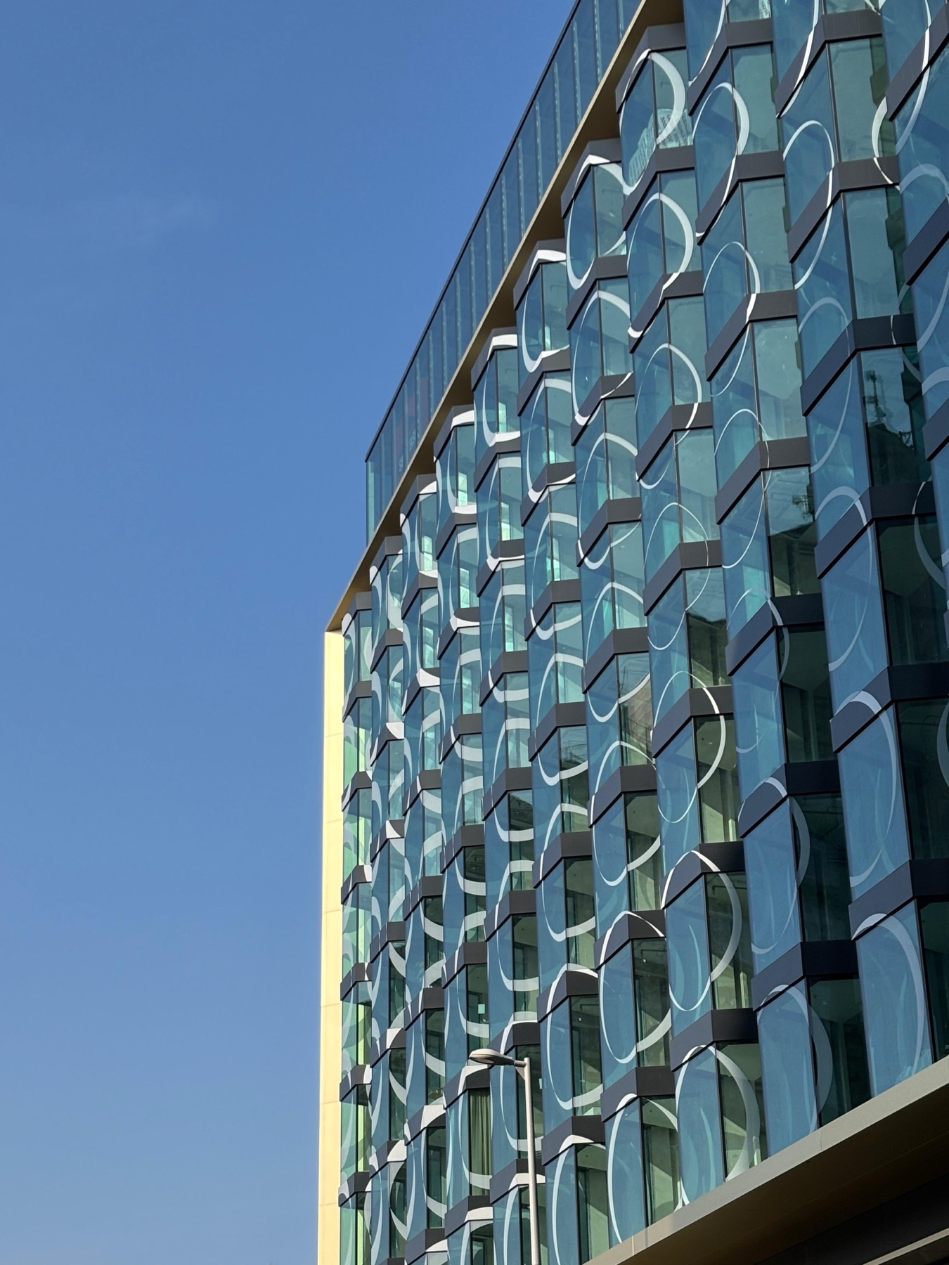 SO/ Budapest Hotel facade under construction — close-up of the circular glass pattern against a clear blue sky