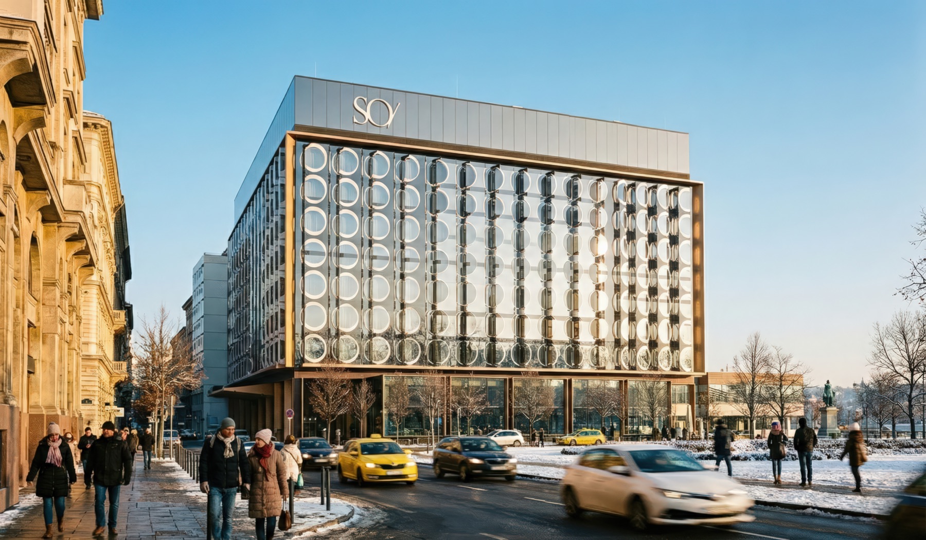 SO/ Budapest Hotel street-level exterior in winter — the full circular facade with SO/ branding, pedestrians, and traffic on the snow-covered boulevard