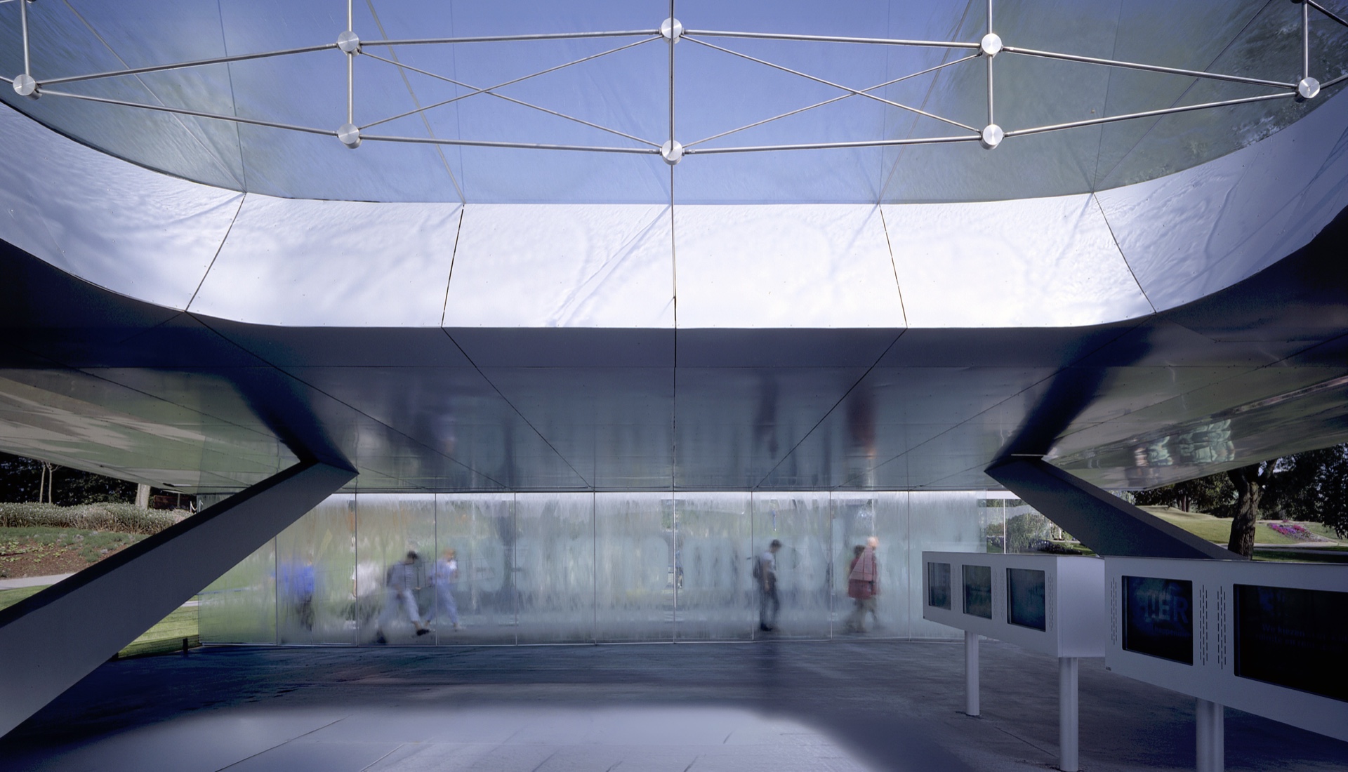 Interior view beneath the HydraPier's tensile glass canopy with water-wall and visitors