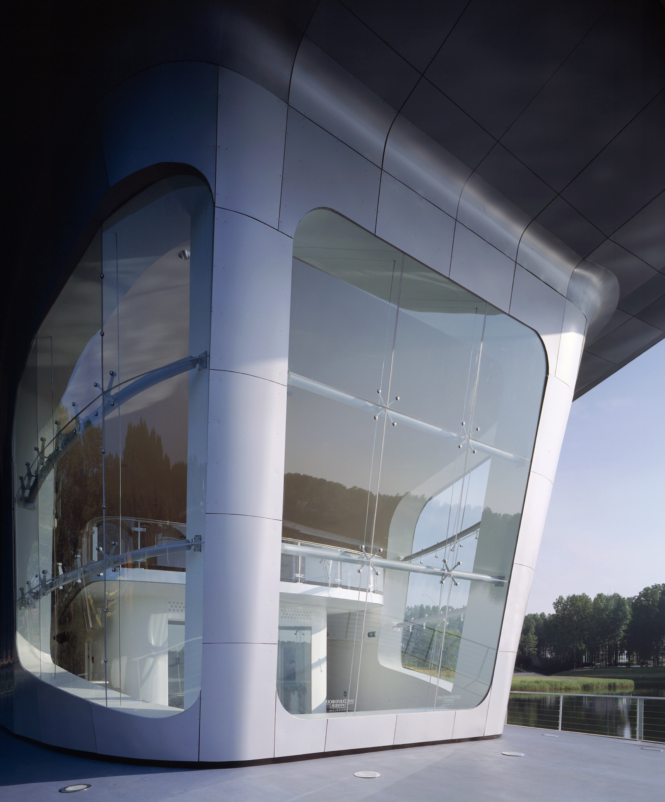 Detail of the pavilion's angular metallic roof plane and glass water-wall facade