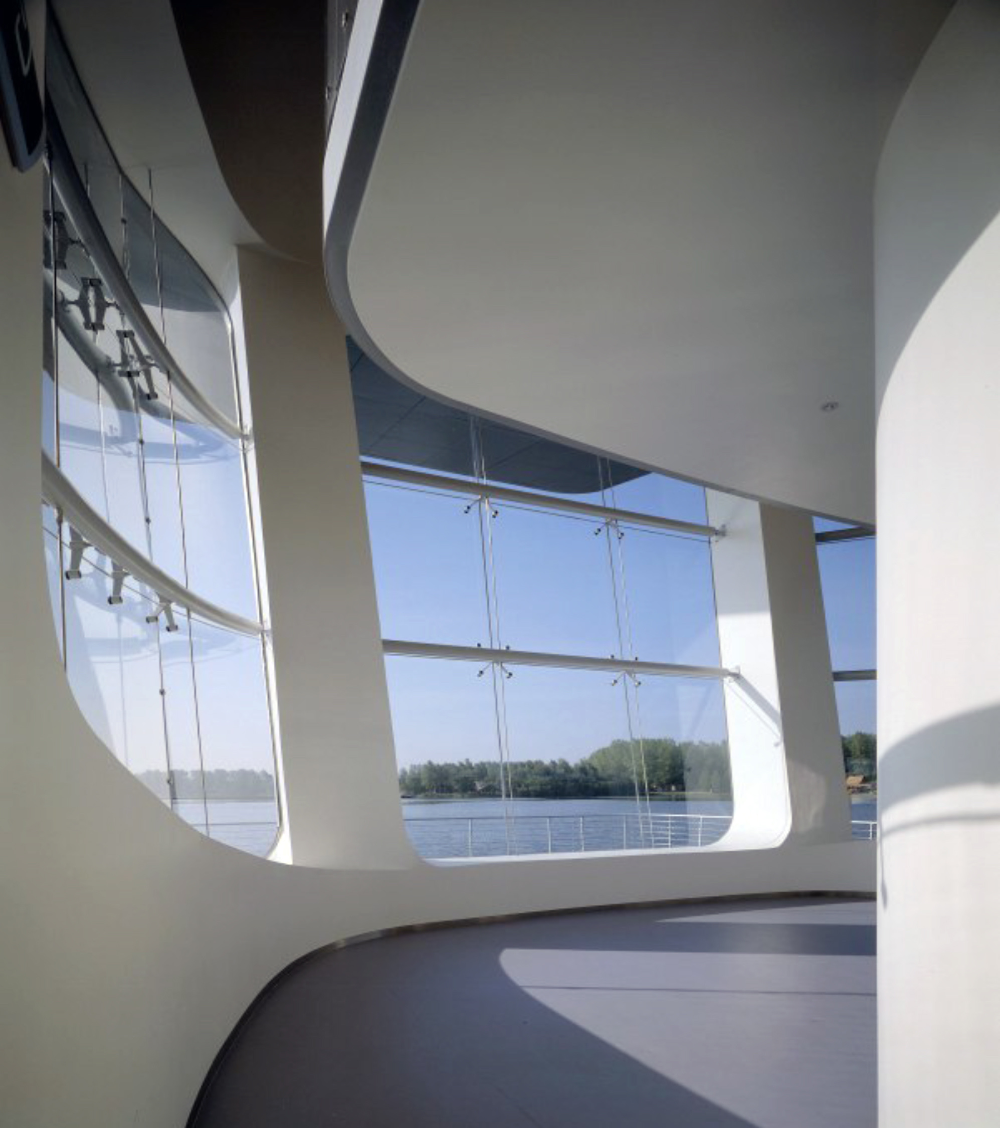 Night view of the illuminated pavilion with its glowing glass walls reflected in the water
