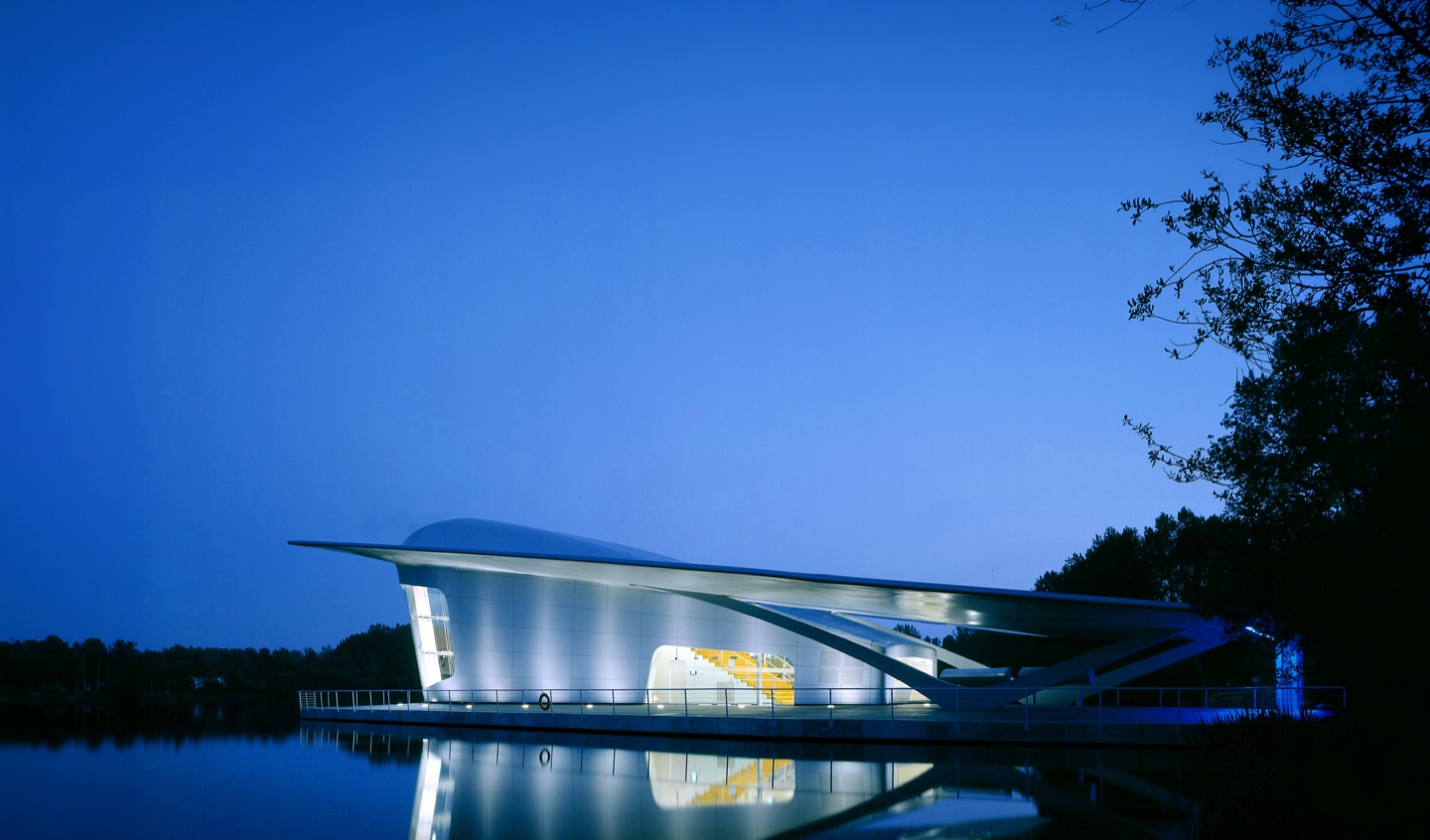 Panoramic view of the HydraPier from across the water showing its angular silhouette and glass walls