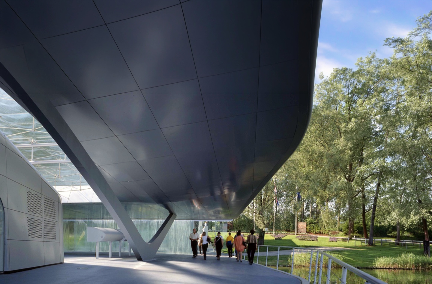 Interior exhibition space with multimedia displays and natural light through the glass roof aperture
