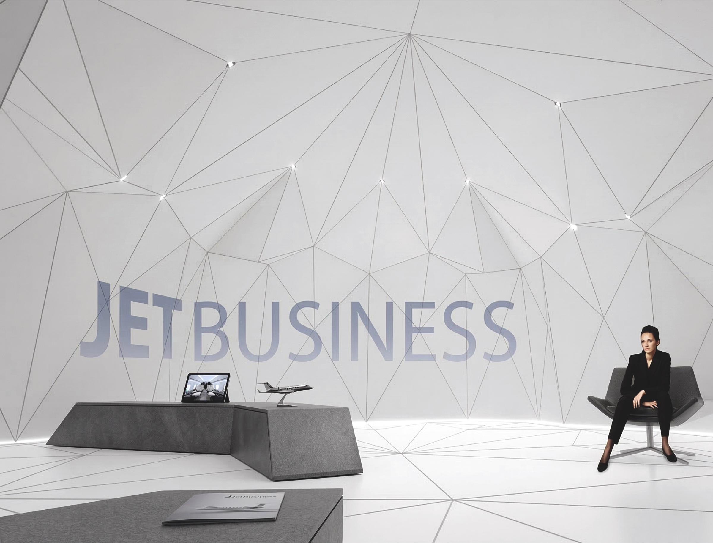 Consultation area inside the pavilion with angular desk, laptop, scale jet model, and JETBUSINESS branding across the faceted white wall behind a seated client