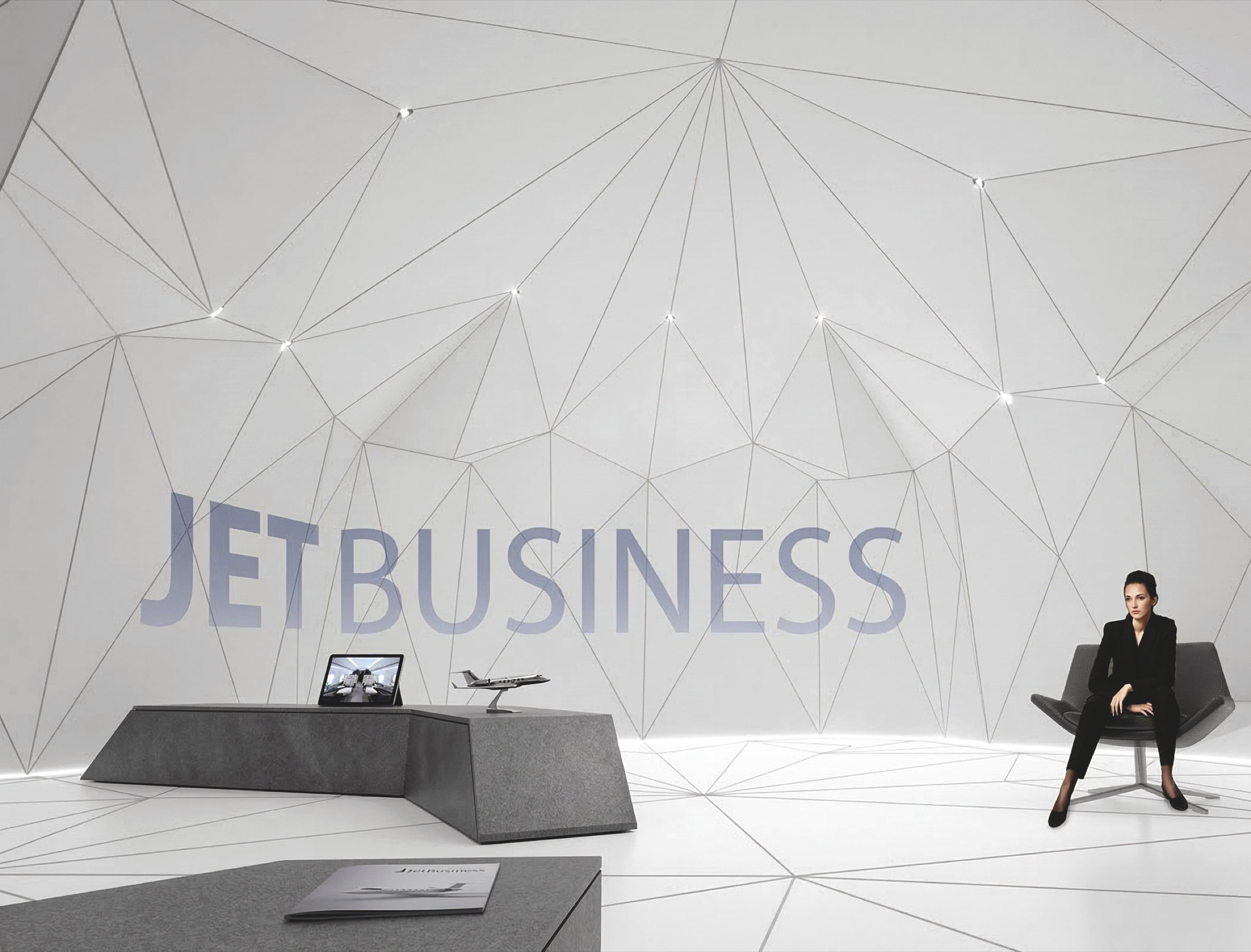 Consultation area inside the pavilion with angular desk, laptop, scale jet model, and JETBUSINESS branding across the faceted white wall behind a seated client