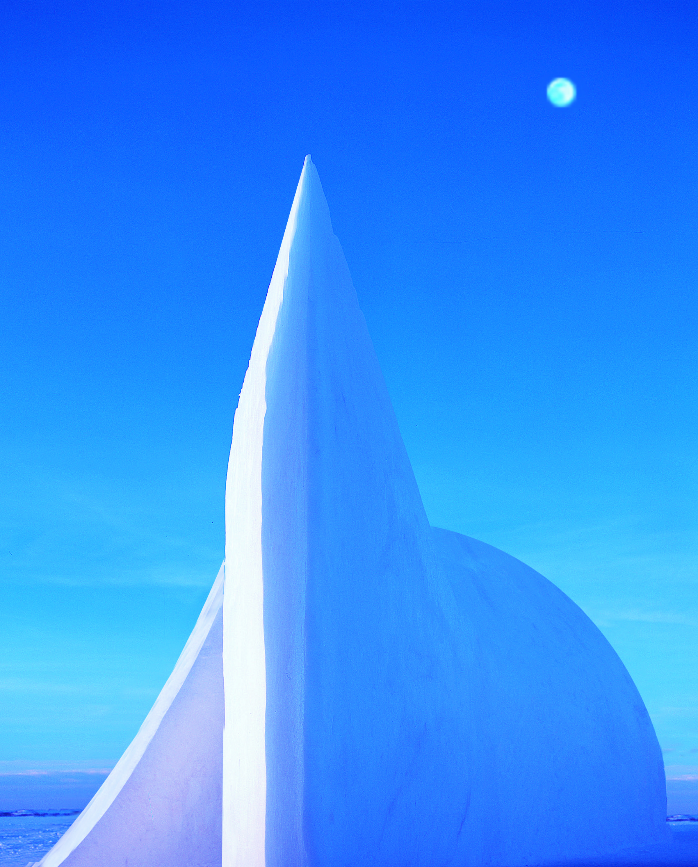 Absolute Zero — a monumental snow form rising to a sharp point against a vivid blue Arctic sky with the moon above, Kemi, Finland