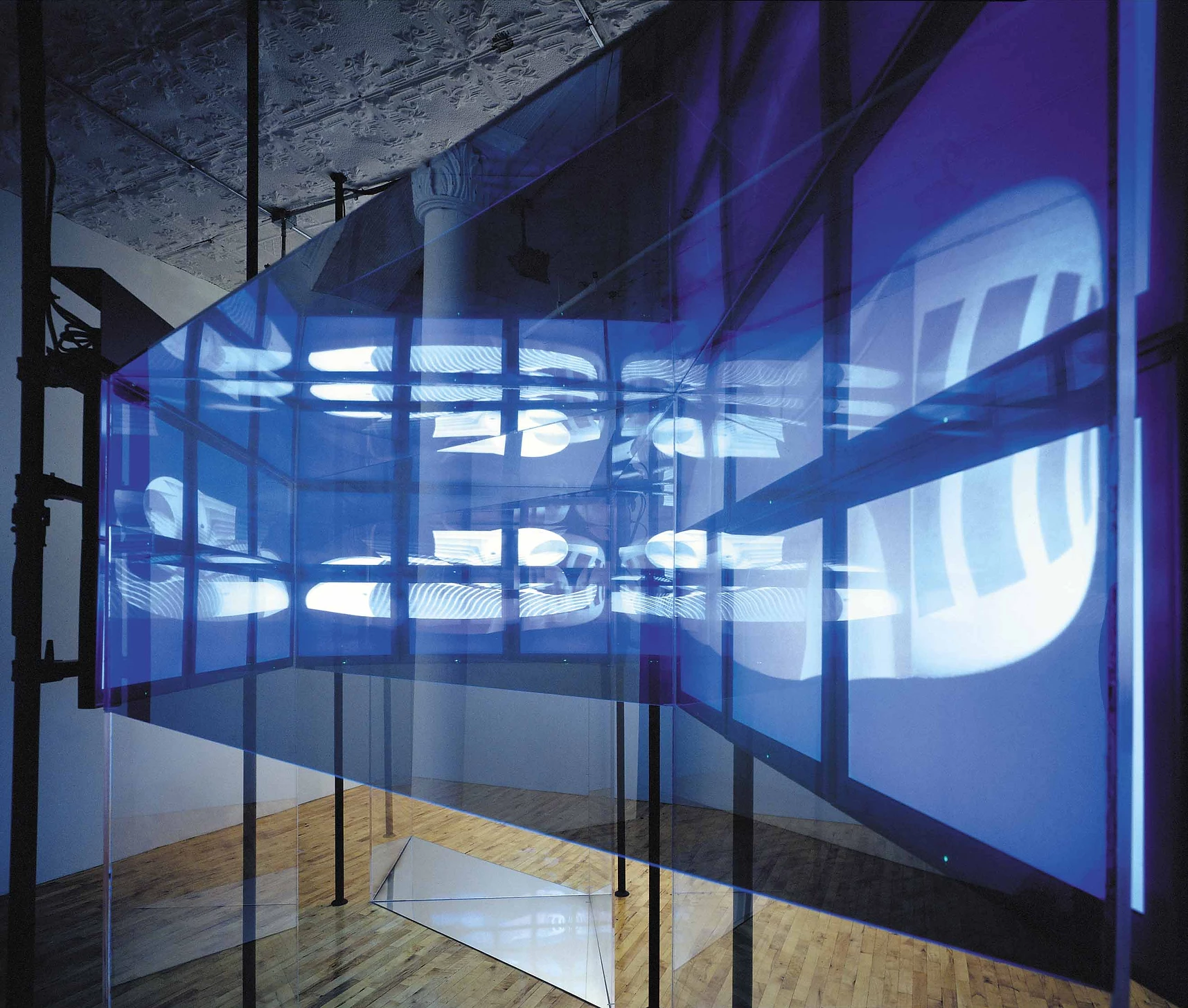 FluxSpace 1.0 at TZ Art — translucent blue glass screens with projected digital imagery suspended in a New York loft gallery, glass floor plane reflecting the projections below