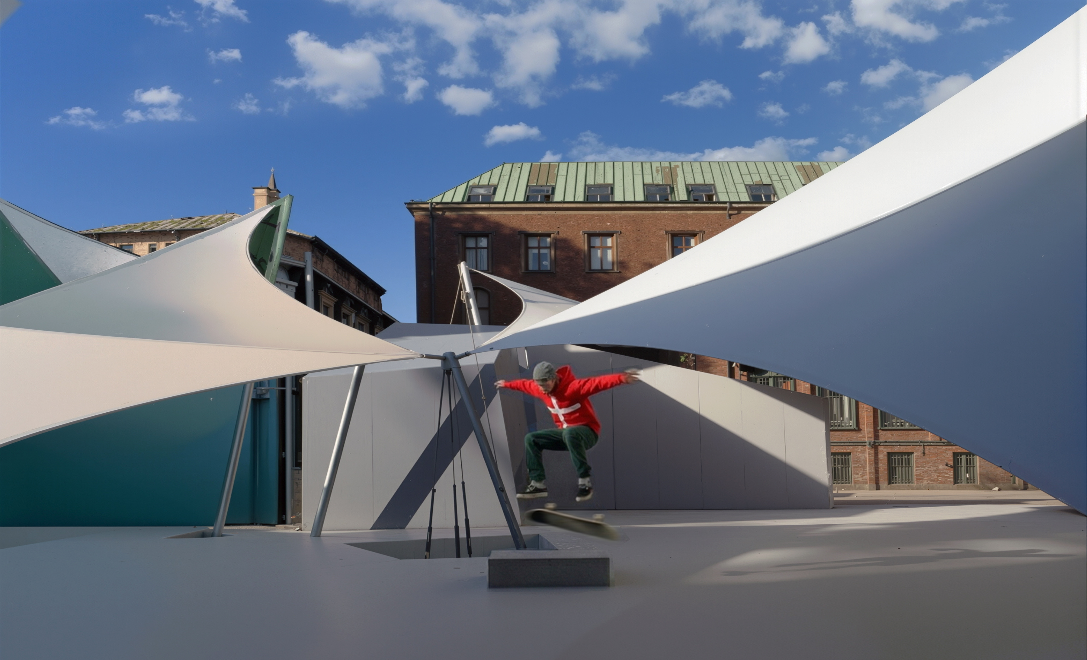 Daytime view of the Univers Theater canopy structure showing sweeping tensile forms against Aarhus historic buildings