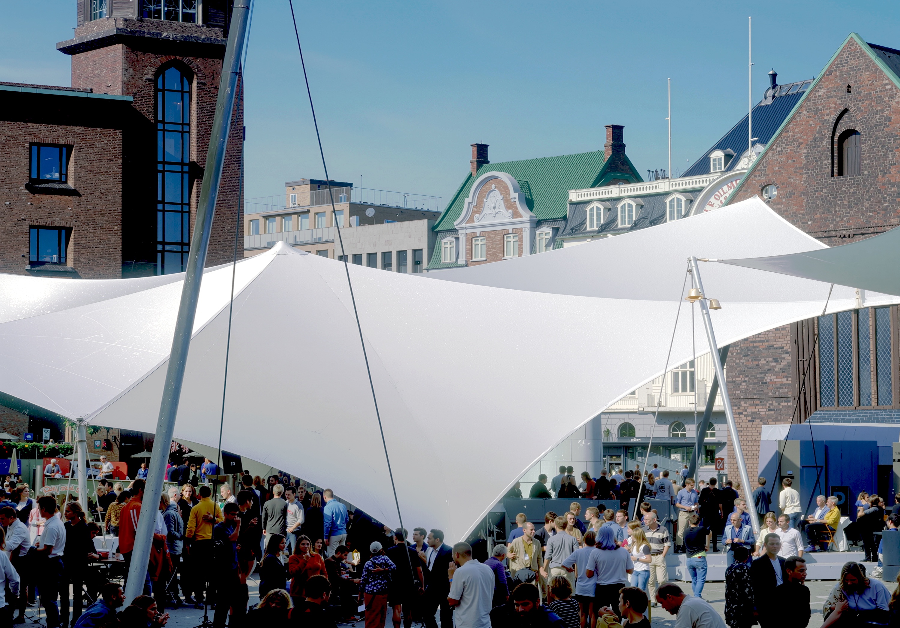 Daytime view of the Univers Theater tensile canopy structure with crowds in Bispetorv Square, Aarhus
