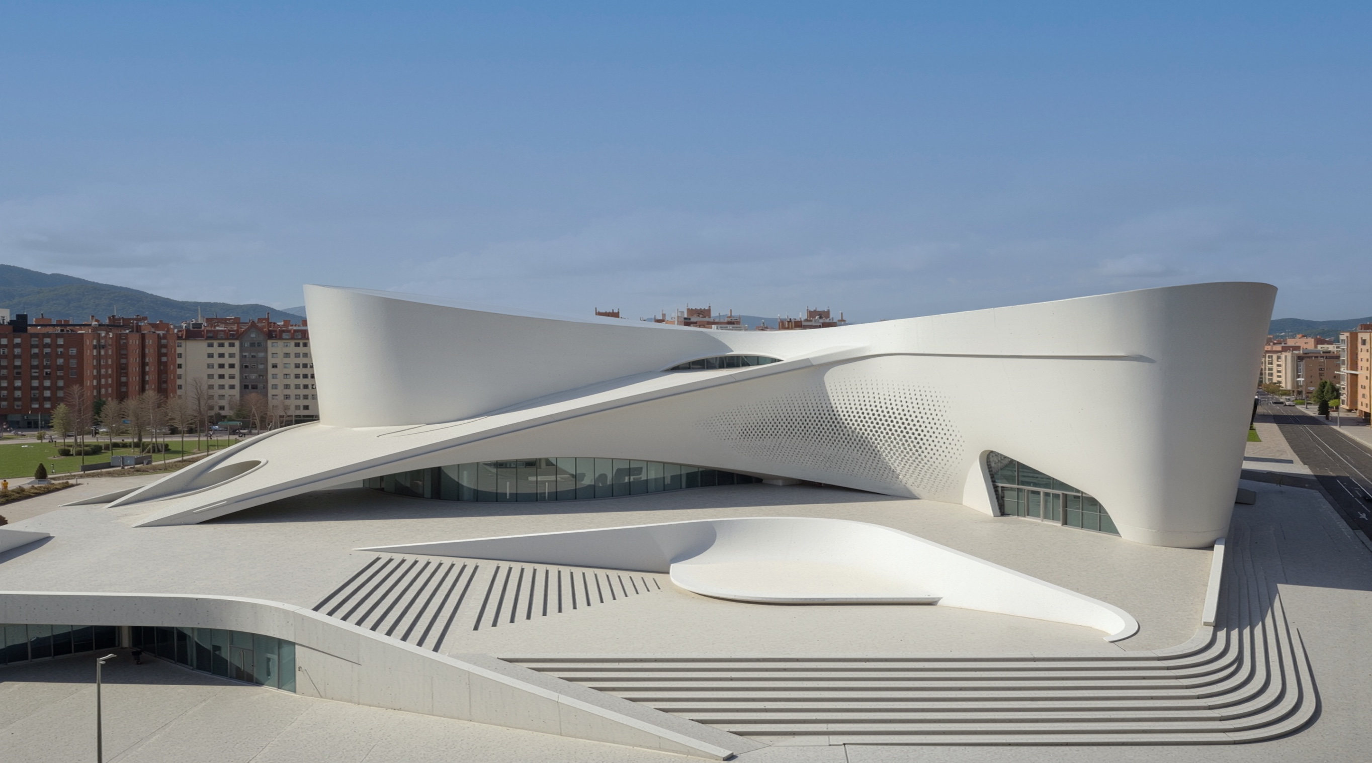 Aerial daytime view of the Vitoria Museum of Contemporary Art showing its sweeping white sculptural form set against the Basque mountain landscape