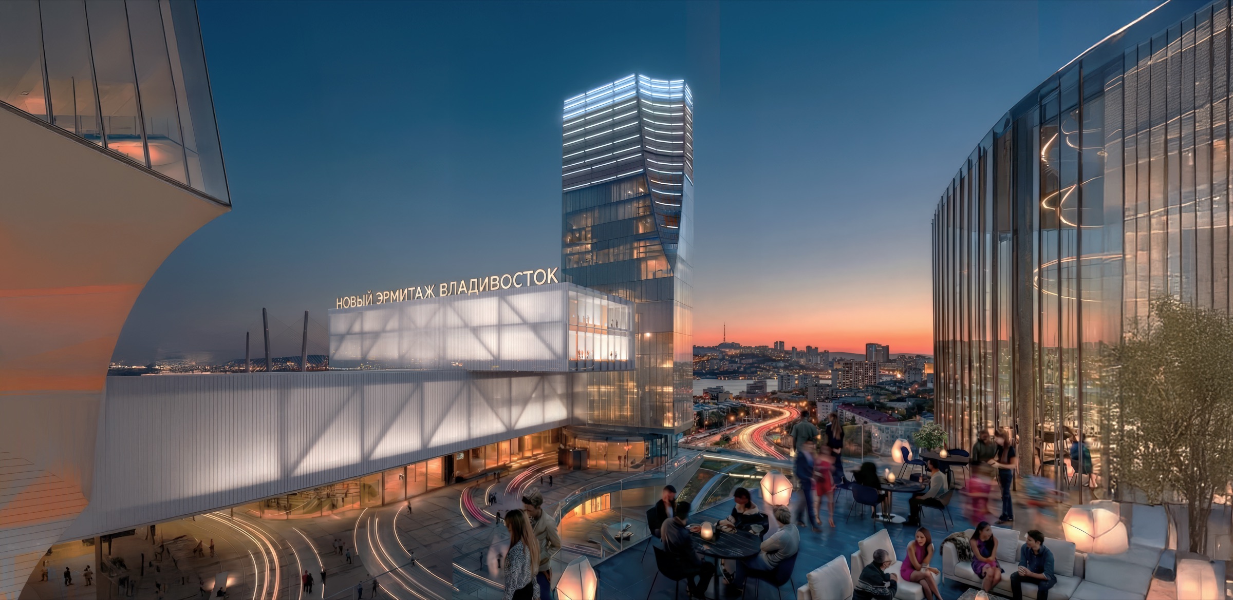 Twilight exterior view of the New Hermitage Vladivostok complex from the harbor, showing the illuminated glass canopy and angular museum volumes with Cyrillic signage reading Новый Эрмитаж Владивосток, a glazed tower rising behind, and visitors on a rooftop terrace with distant harbor lights