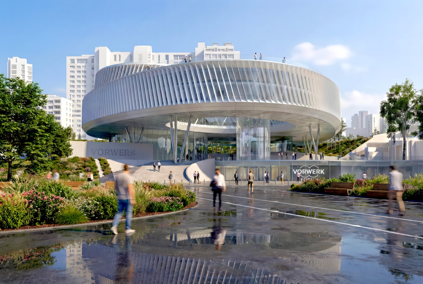 Vorwerk Headquarters exterior approach with Vorwerk signage, landscaped gardens, and rain-slicked plaza at dusk