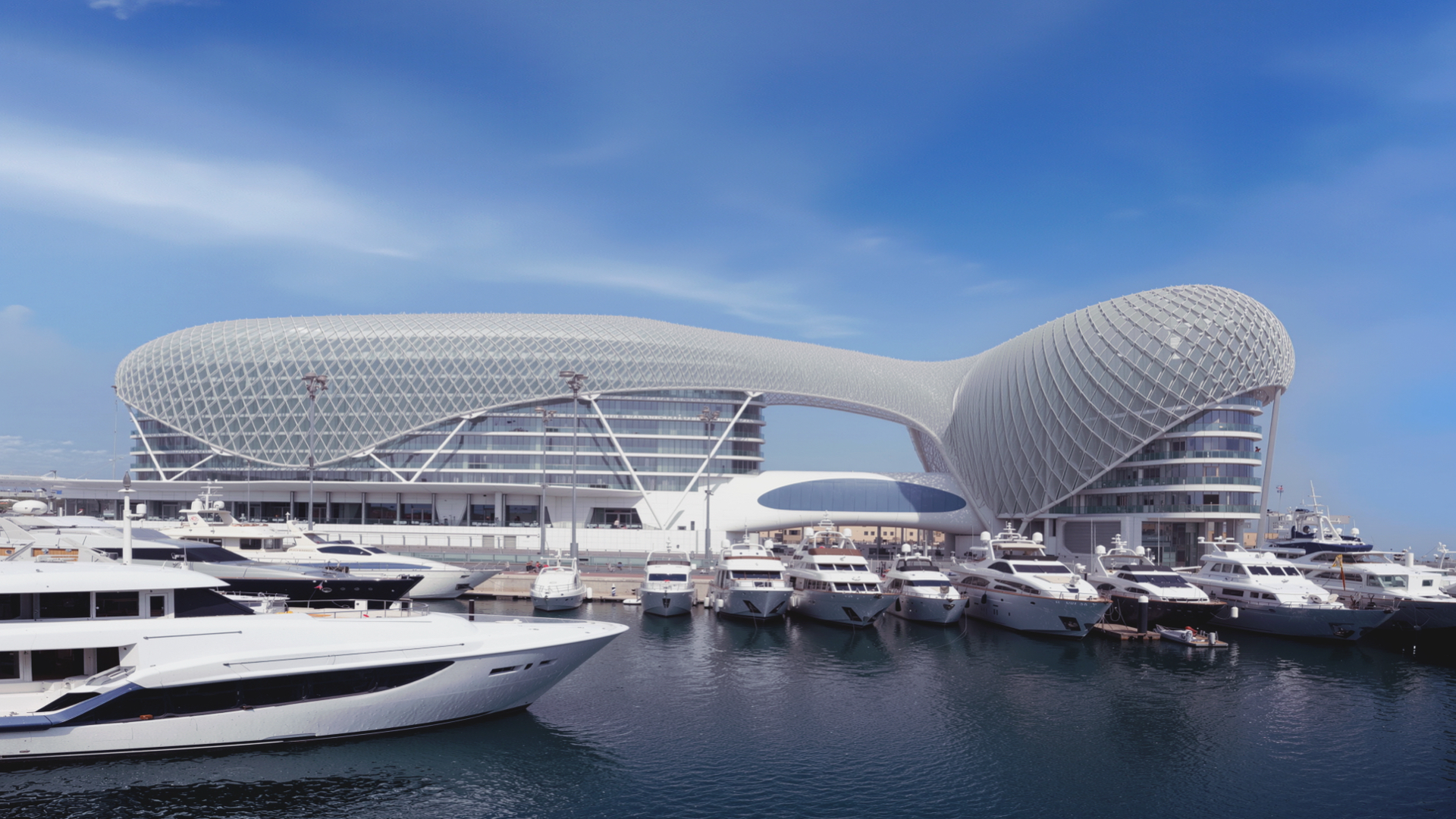 Yas Hotel viewed from the marina with yachts and the grid-shell structure against the sky